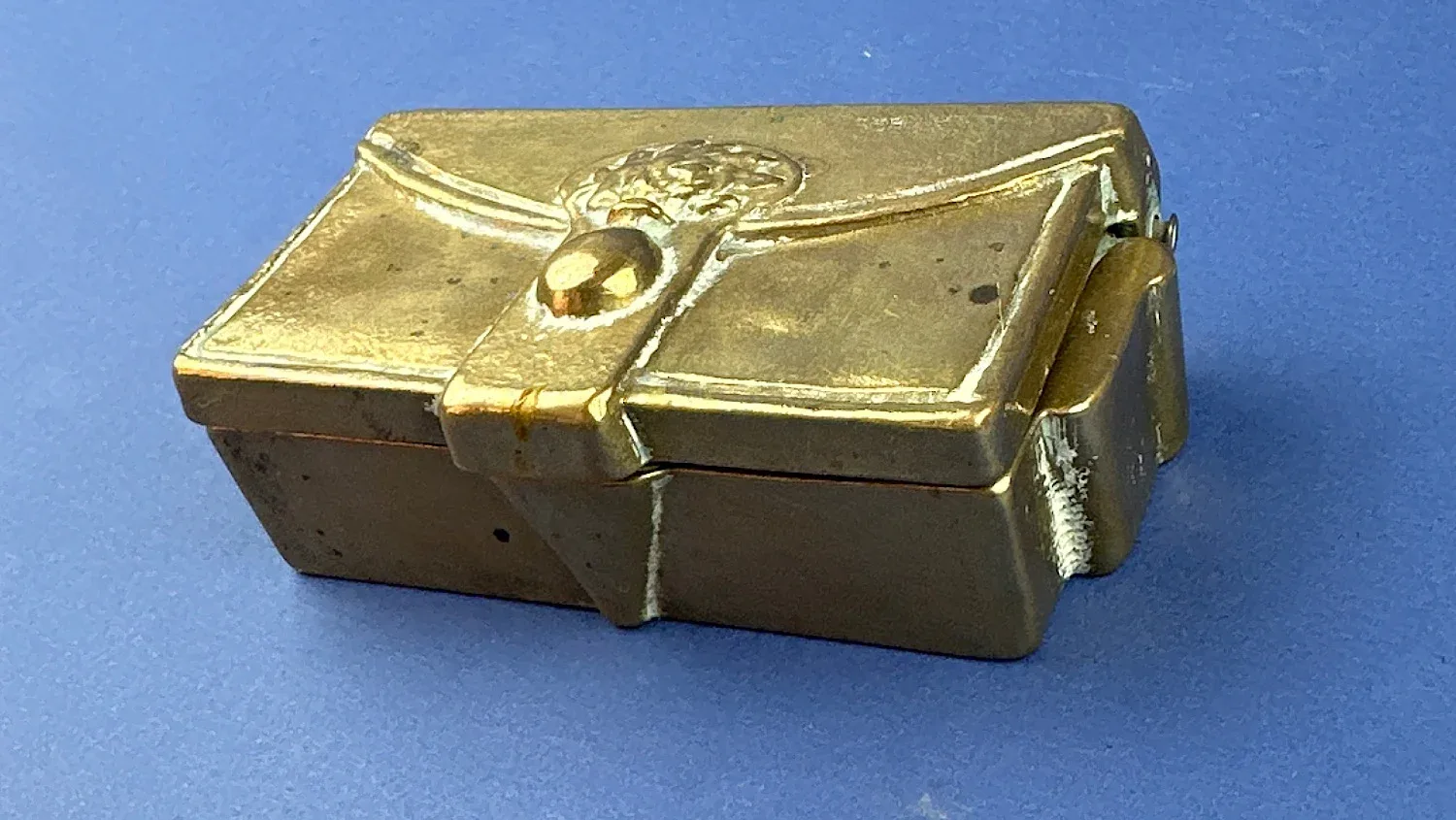 Vintage trench art brass keepsake box angled front view with decorative clasp