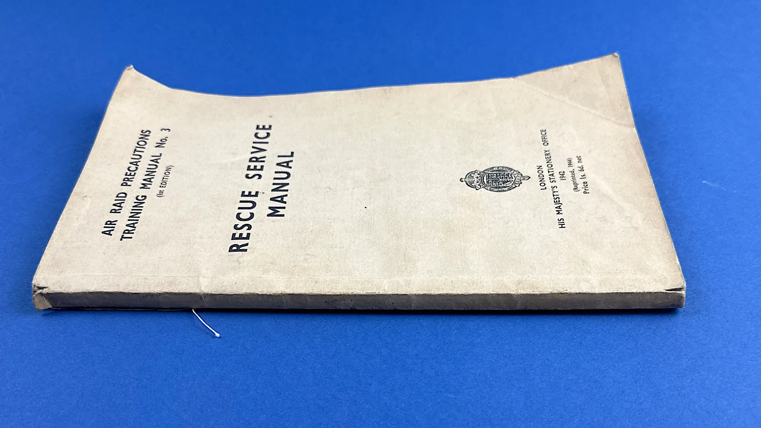 Side view of the WW2 ARP Rescue Service Manual showing spine wear and wartime kraft-paper covers