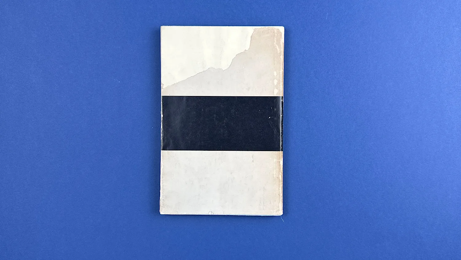 Back cover of Bureaucrats in Battledress showing surface paper loss to the upper section of the card wrap