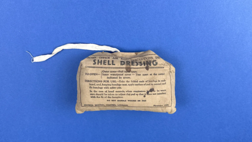 Front view of unopened 1938 ARP Shell Dressing by Arthur Berton Ltd showing printed Home Office ARP label and original ties