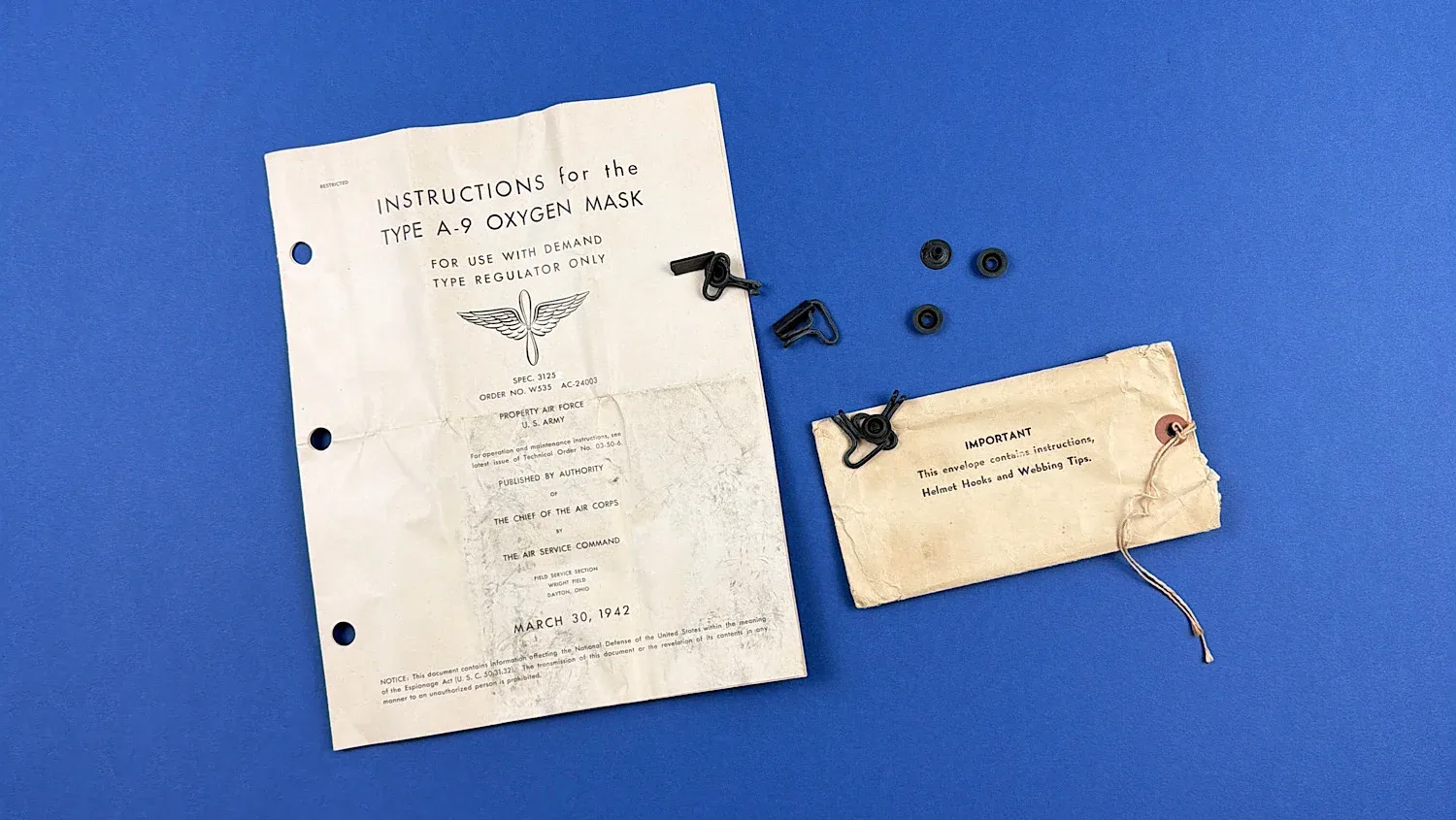 WW2 USAAF Type A-9 oxygen mask instruction sheet dated 30 March 1942 with original envelope helmet hooks and webbing fittings displayed together