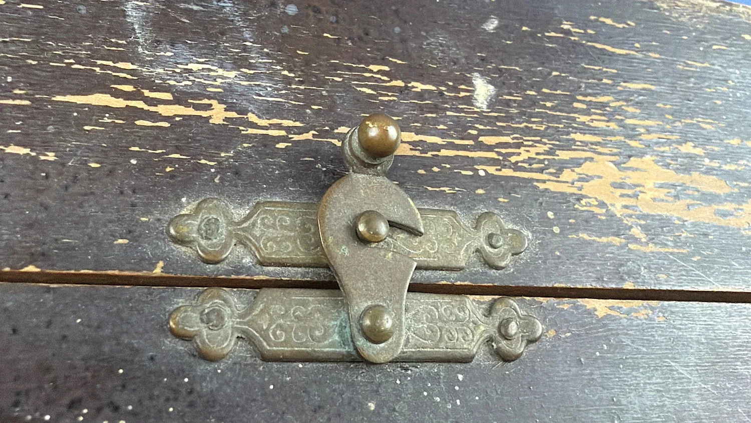Close up of original brass latch on British Home Front Boots “Home” First Aid Case showing period hardware and surface wear