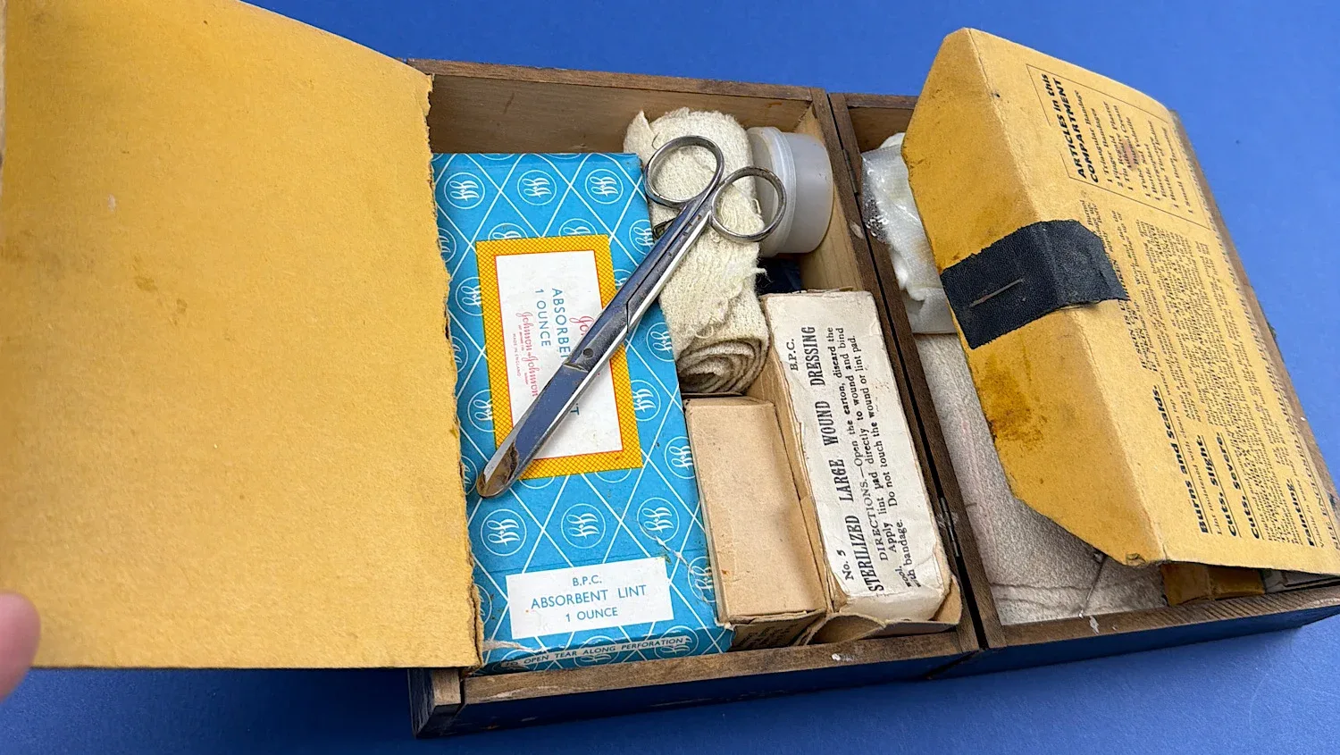 British Home Front Boots “Home” First Aid Case interior showing original compartments with period bandages absorbent lint scissors and boxed medical supplies