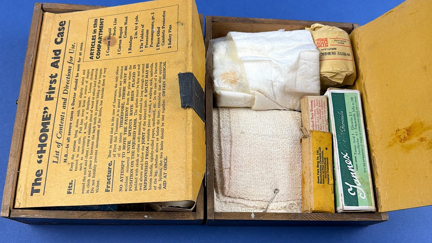 British Home Front Boots “Home” First Aid Case fully opened showing original printed instruction panels and mixed period contents arranged in compartments