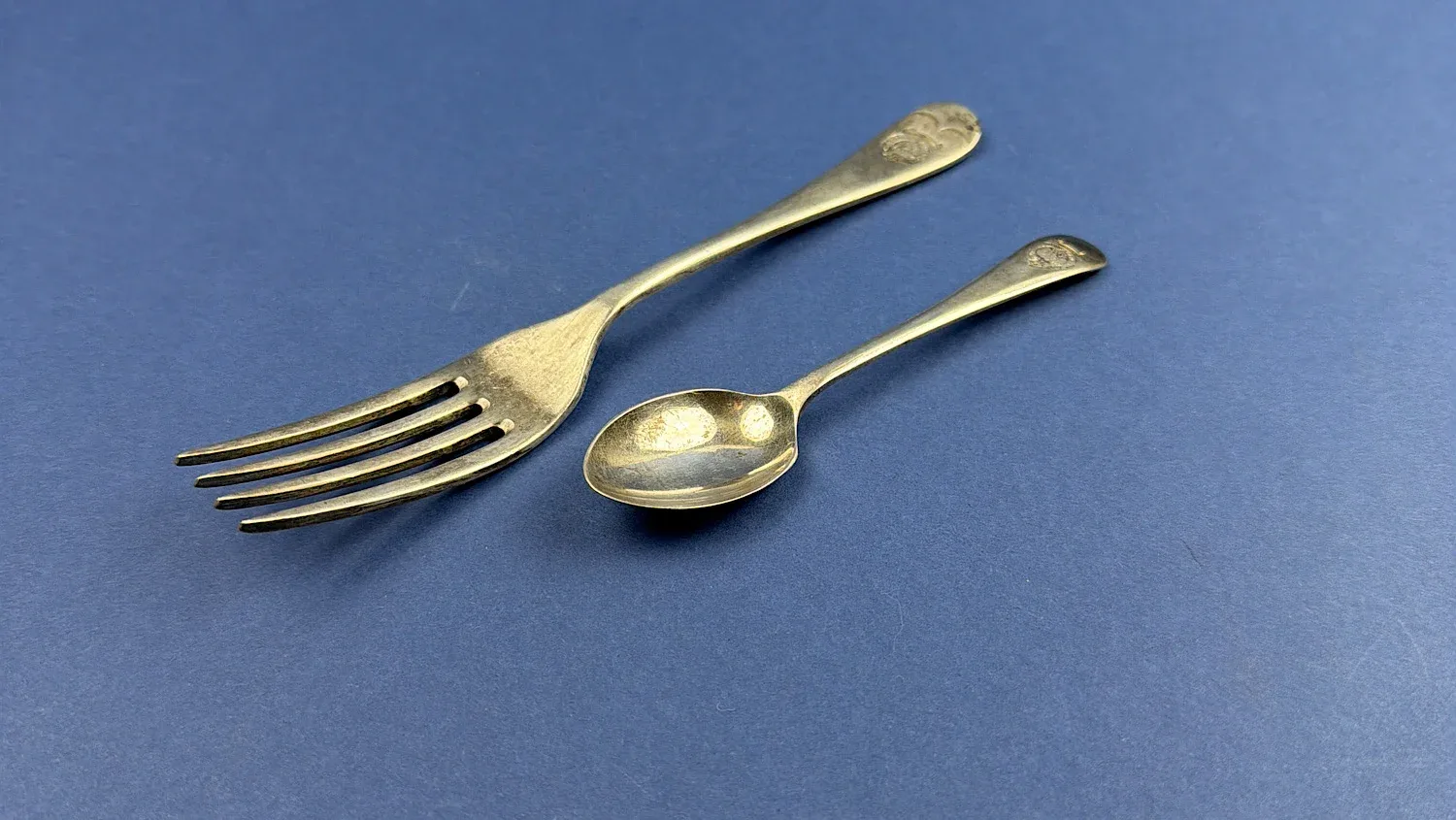 WW2 NAAFI fork and teaspoon set photographed together at an angle showing overall form and service wear Home Front