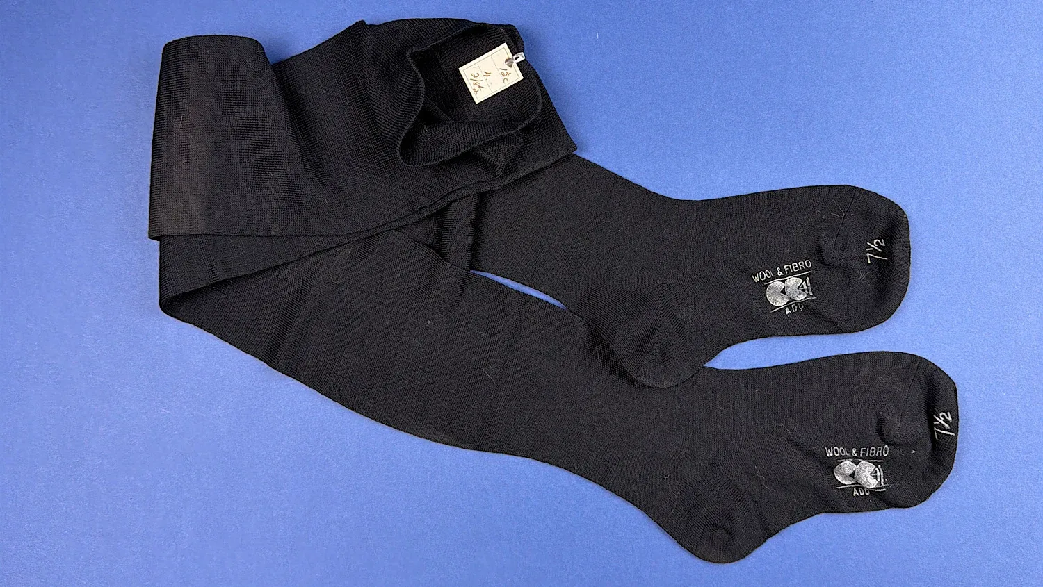 Pair of unworn WW2 CC41 black wool stockings laid out flat showing full length and overall condition