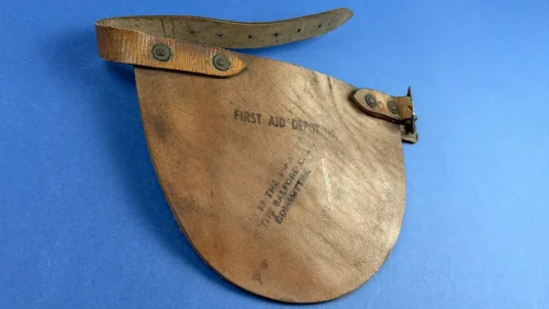 Angled view of WW2 ARP stretcher bearer leather knee pad showing strap and buckle Salford Civil Defence Home Front gear