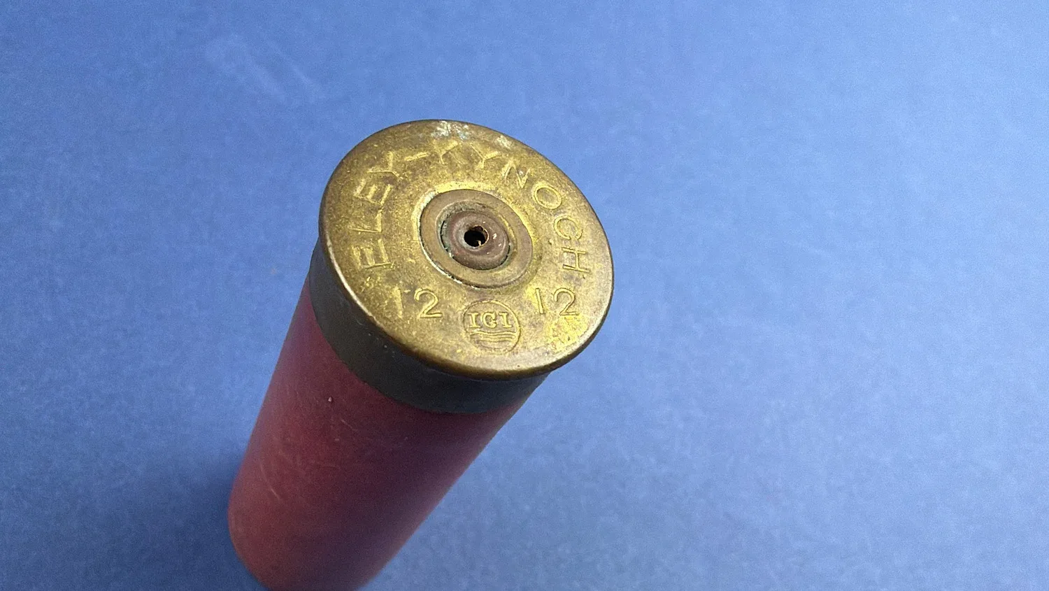 Angled close up of brass head showing Eley Kynoch 12 12 headstamp and drilled primer on WW2 British 12 Bore solid ball cartridge
