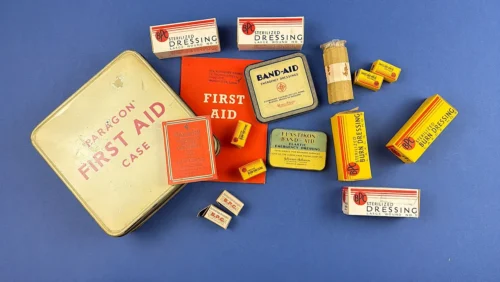 WW2 era Paragon First Aid Case and contents displayed including BPC dressings Band-Aid tin Elastikon bandage and first aid booklet