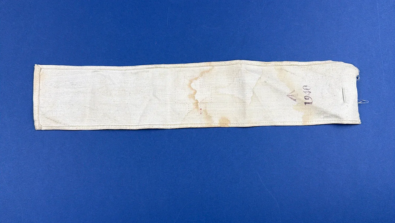 Full reverse view of WW2 British Red Cross armband with visible staining and wear
