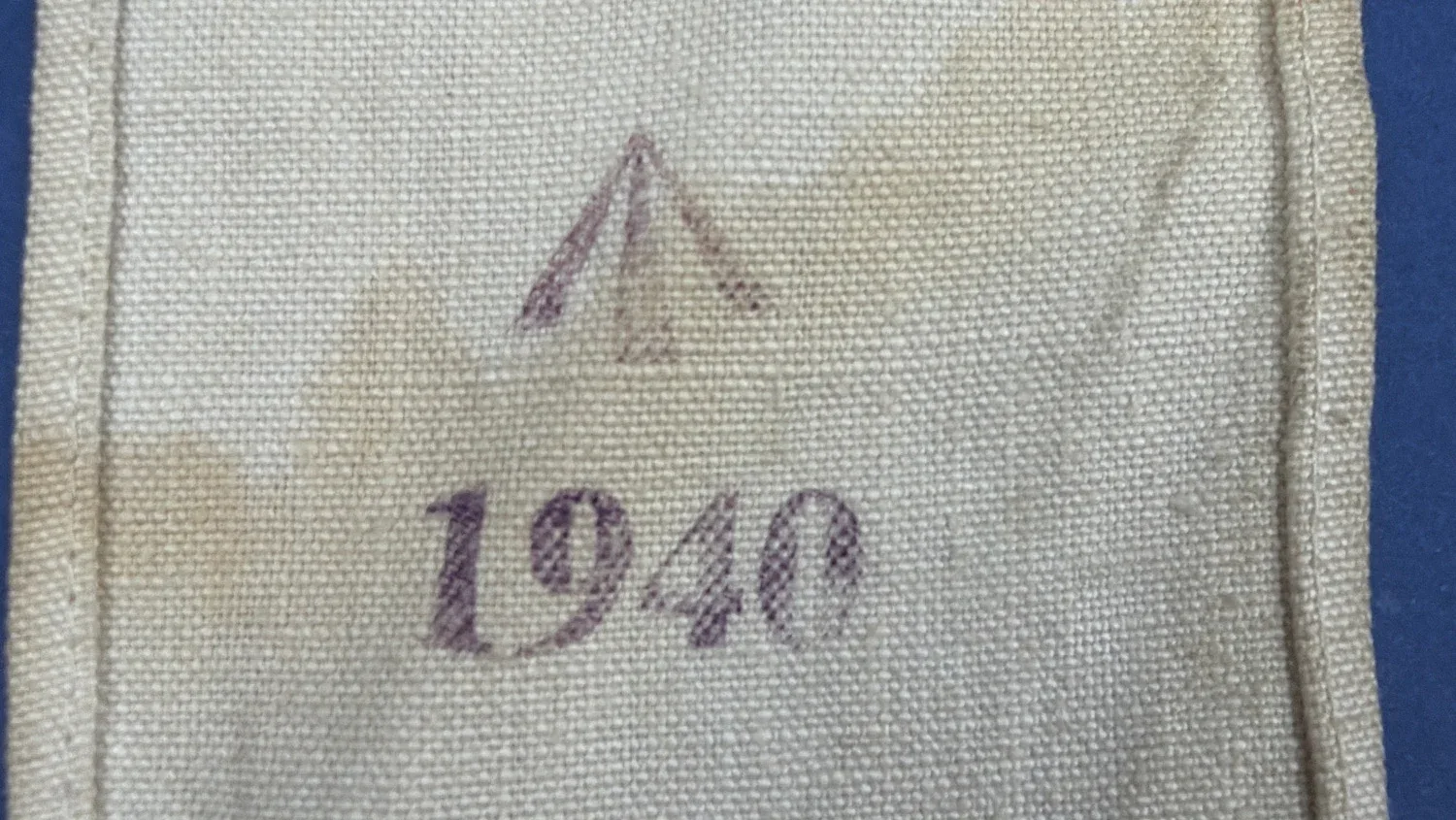 Detailed view of Broad Arrow marking and 1940 date stamp on WW2 British Red Cross armband