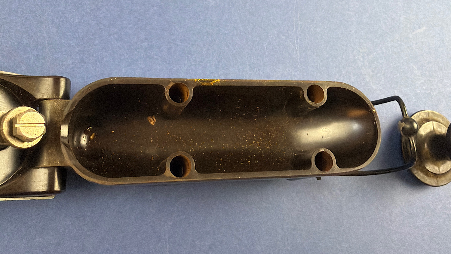 Inside of the RAF aircraft Morse key showing the empty rounded casing section and wire loop