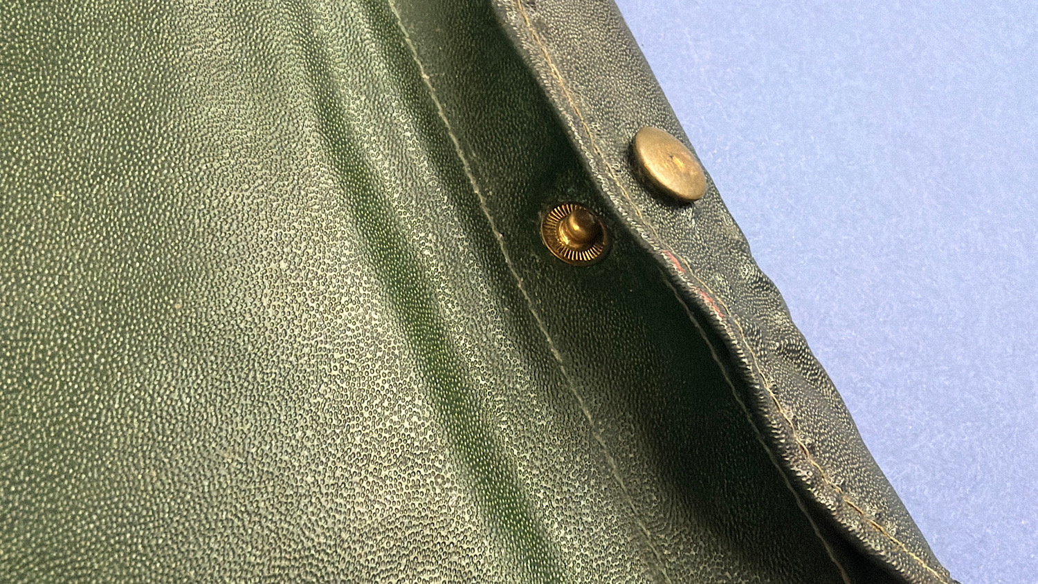 Close up of green waterproofed cover and press stud fastening on WW2 British Drivers M.T. Notes sleeve