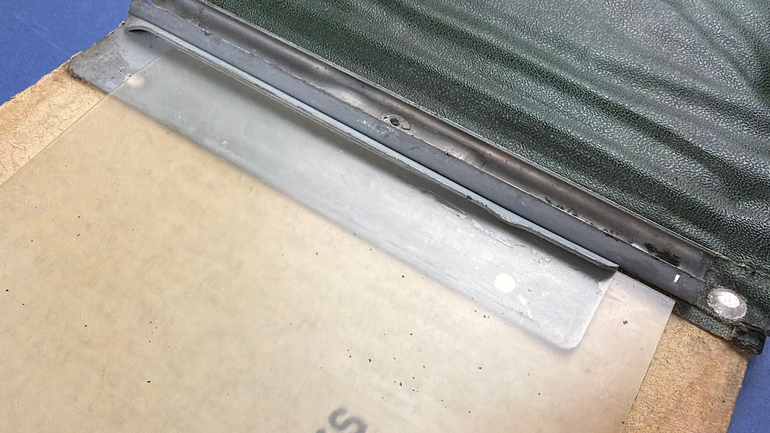 Close up of metal retaining strip and clear movable plastic screen on WW2 British Drivers M.T. Notes sleeve