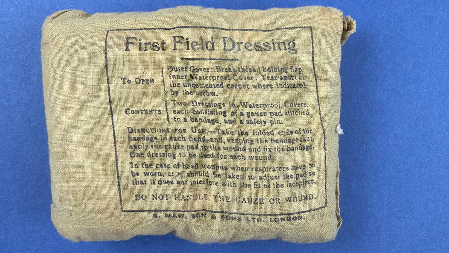 Original WW2 British First Field Dressing in sealed khaki wrapper with printed instructions and manufacturer details