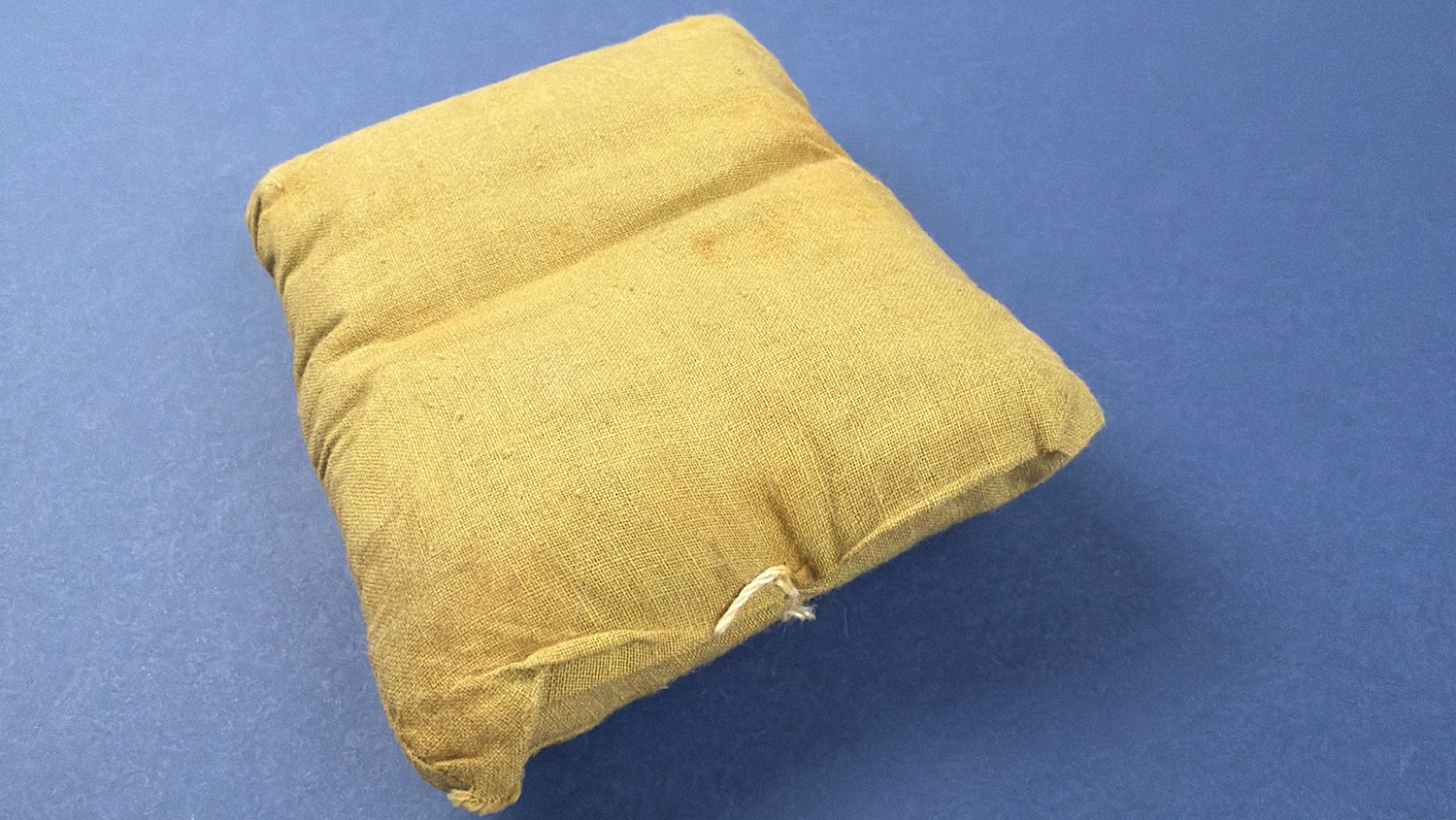 Rear view of unopened WW2 British First Field Dressing with original closure cord visible