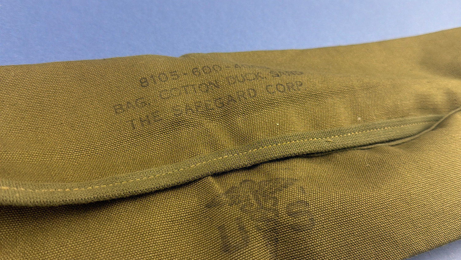 Angled view of WW2 U.S. Army sandbag showing Safeguard Corp manufacturer markings and inspection stamp