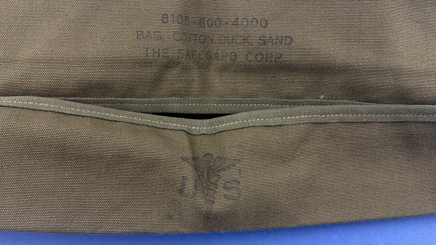 WW2 U.S. Army cotton duck sandbag showing original Safeguard Corp markings and inspection stamp visible through canvas folds