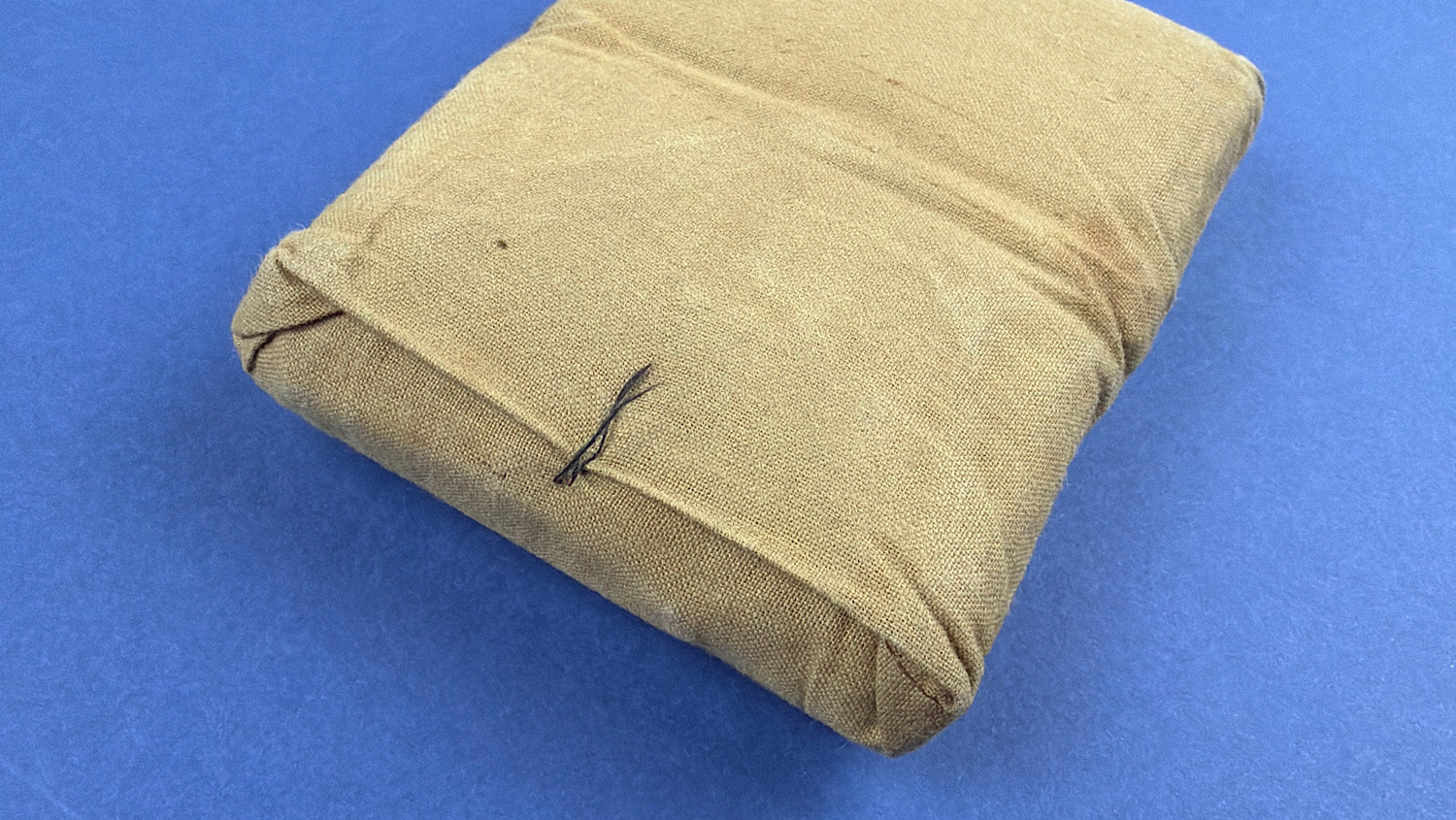 Reverse angled view of original WW2 British Army First Field Dressing showing opening pull cord