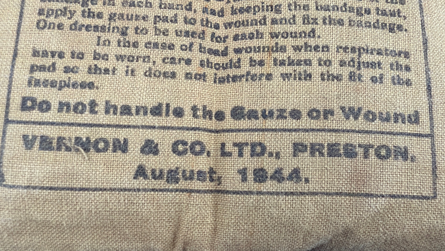 Close up of Vernon & Co Ltd Preston maker mark with August 1944 date stamp on WW2 First Field Dressing