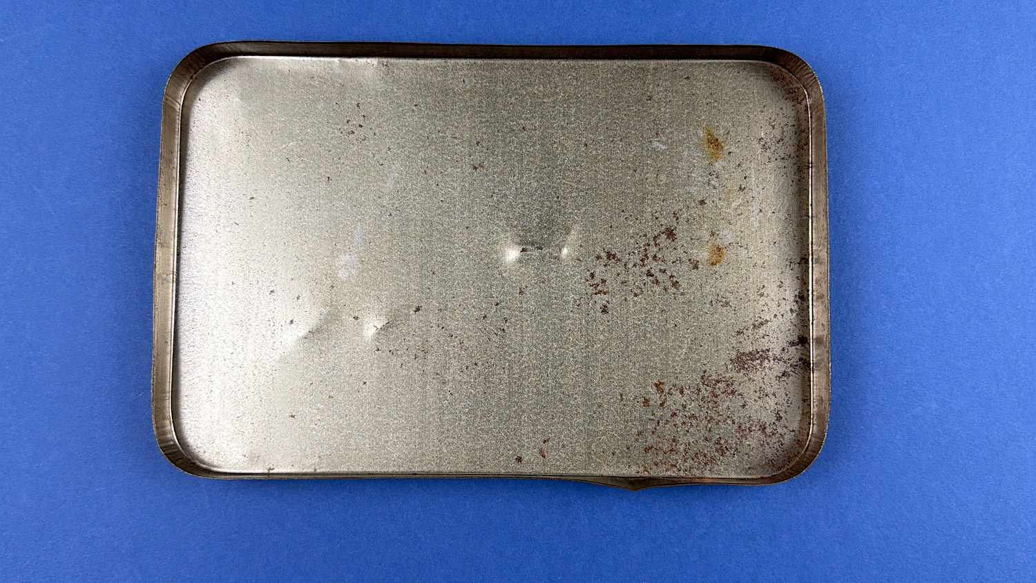 Underside of lid showing age-related wear and surface oxidation to original WW2 ration tin