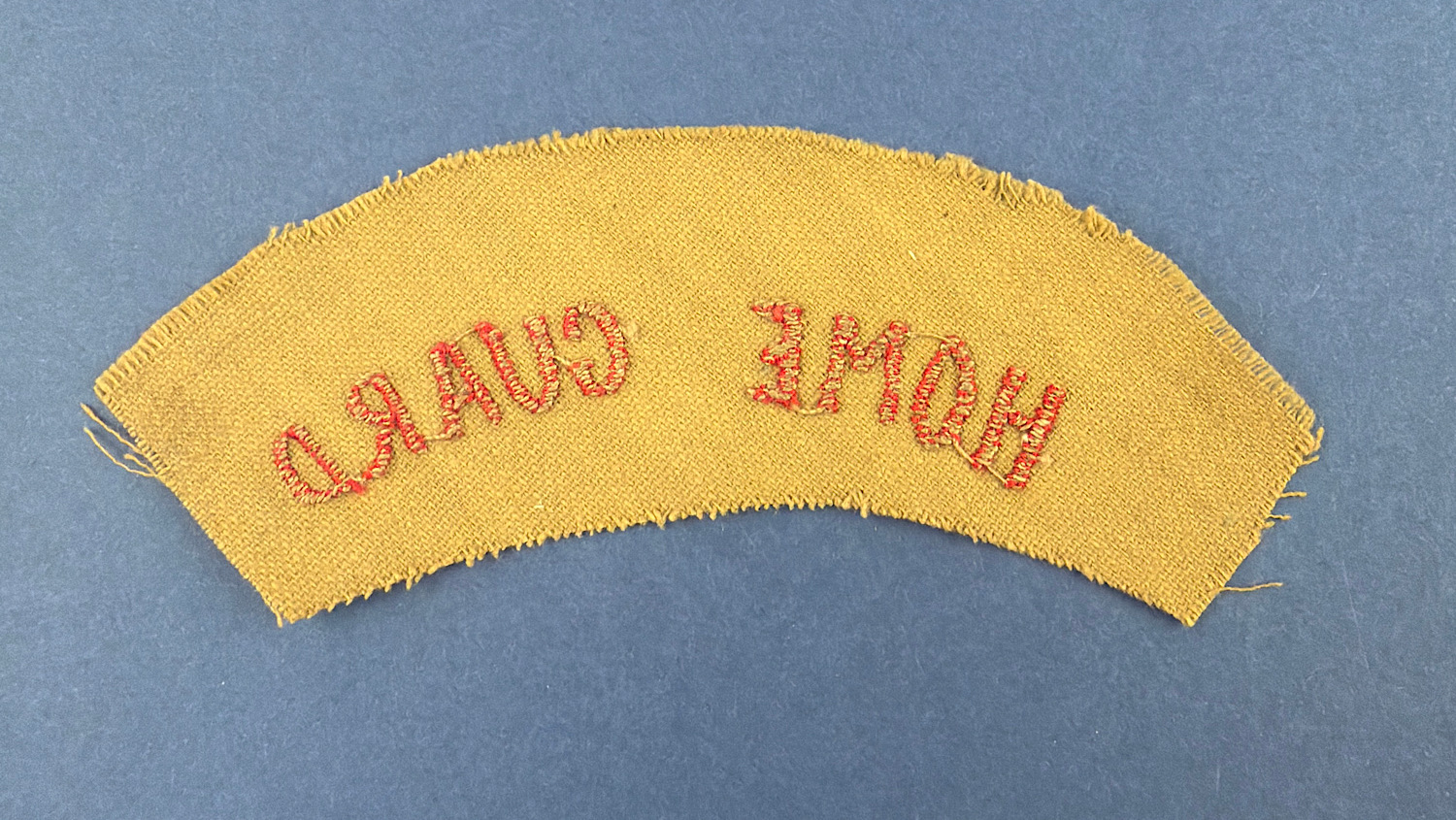 Reverse view of original WW2 Home Guard cloth shoulder title showing red embroidered HOME GUARD lettering