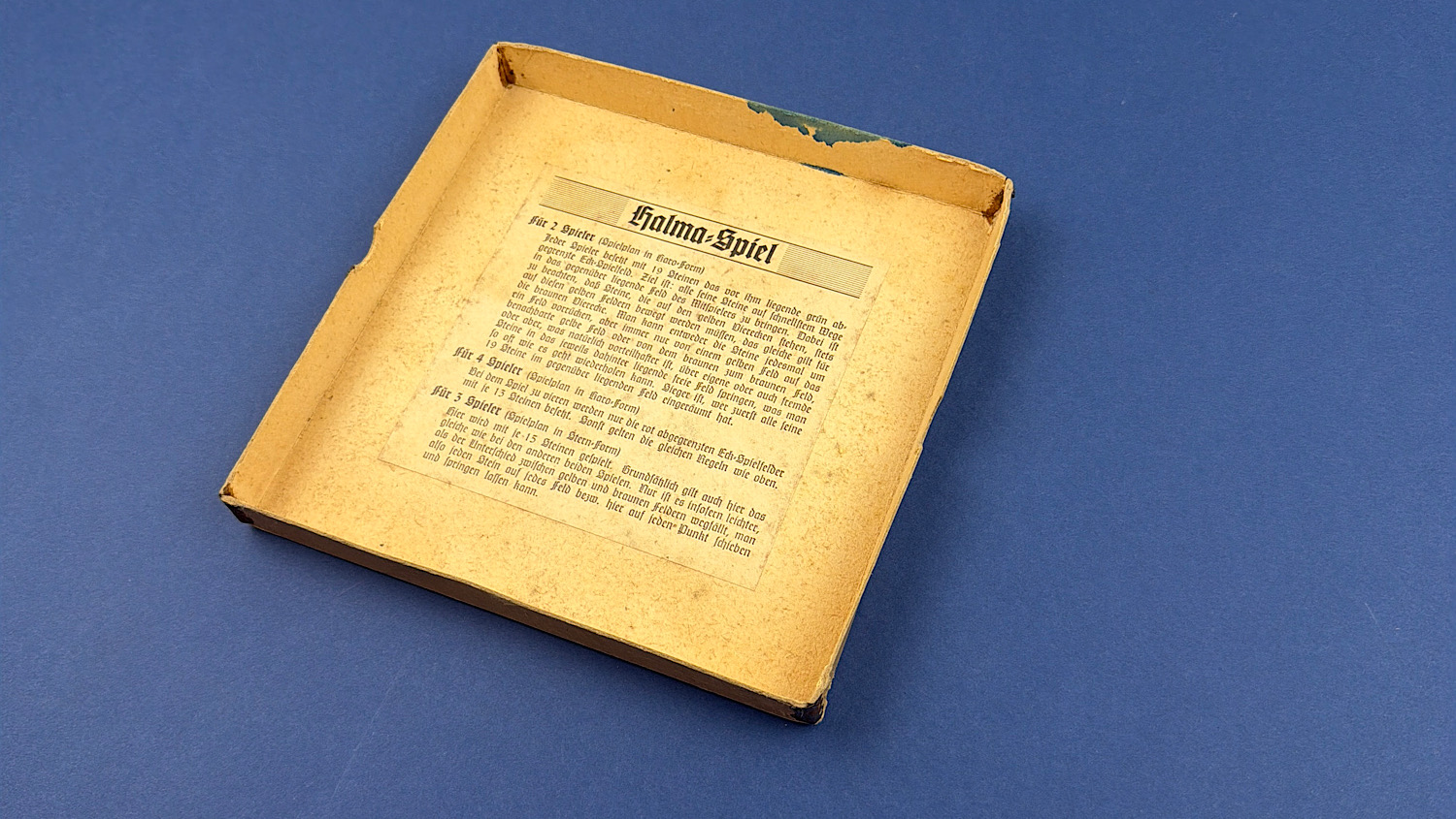 Original box interior showing the printed German Halma-Spiel rules attached inside the lid.