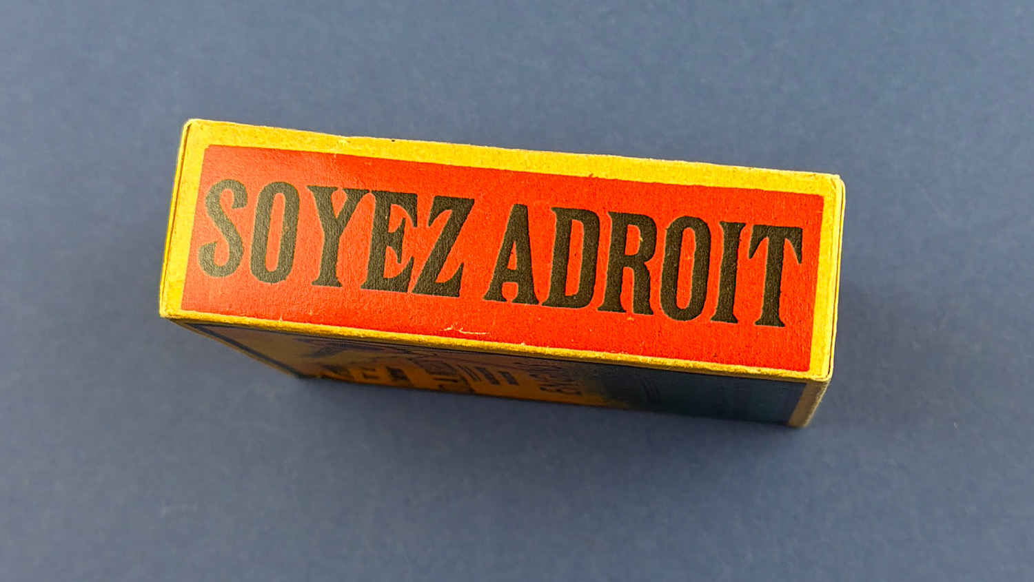 Original side view of the sealed WW2 French anti-Hitler propaganda dexterity toy displaying the French slogan "Soyez Adroit" ("Be Skillful").