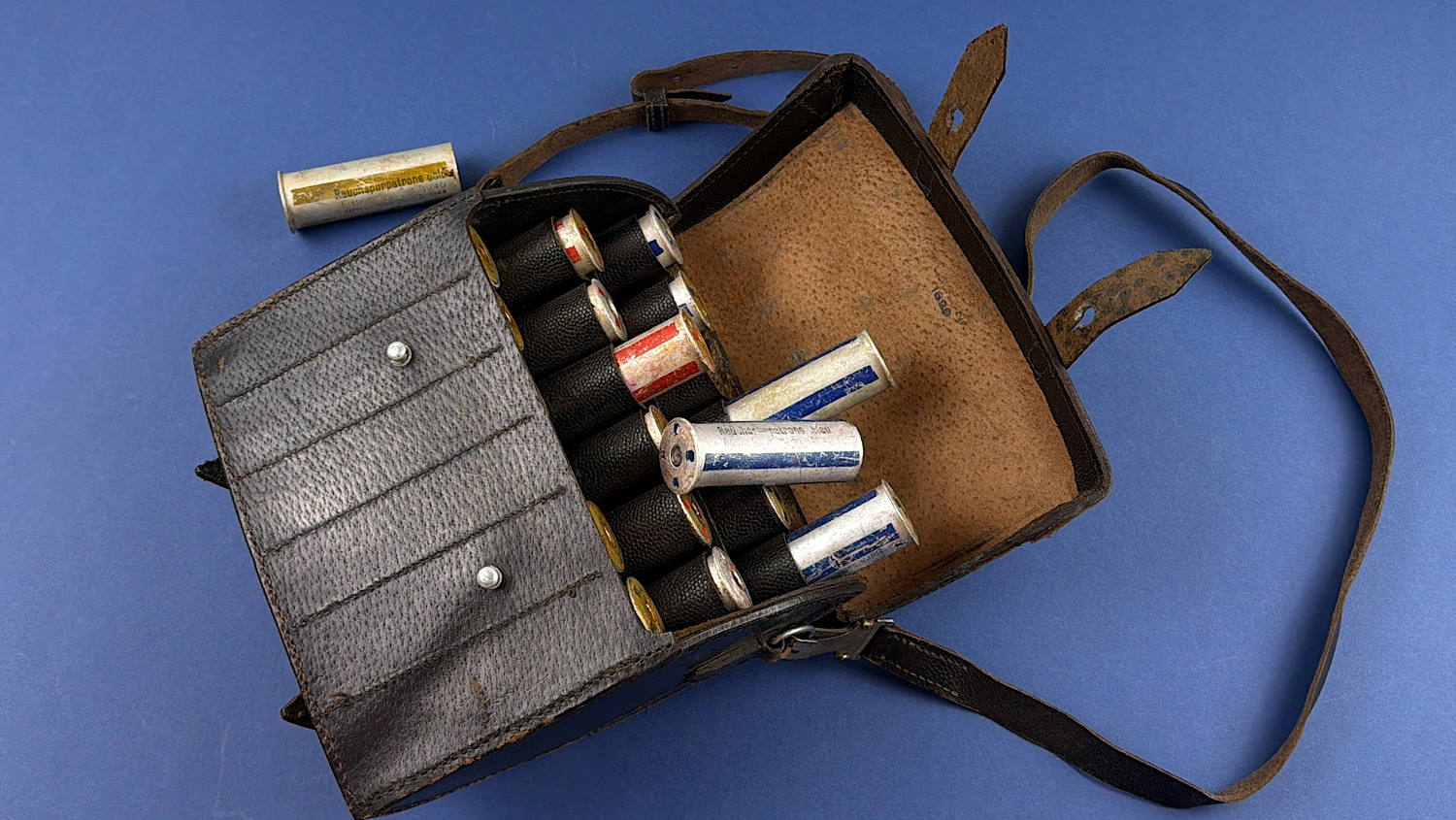 Original WW2 German leather flare pistol signal cartridge carrying case opened to display its 18 cartridge compartments and original inert signal cartridges.