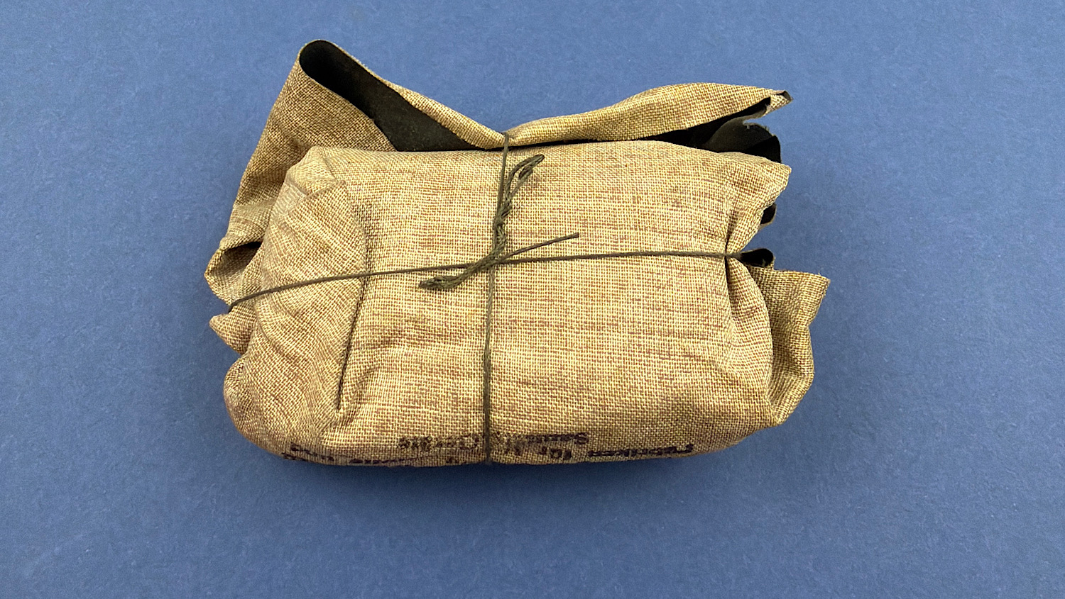 Rear view of the original German WW2 1944 Verbandpäckchen showing the intact hessian outer wrapper and original factory string tie.