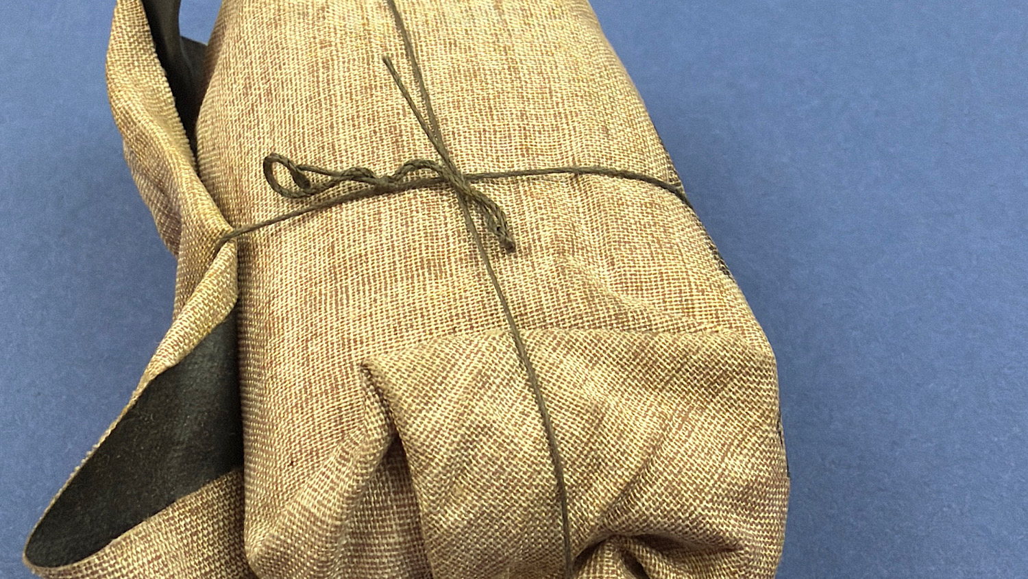 Close-up of the original factory string tie securing the unopened 1944 German WW2 Verbandpäckchen field dressing.