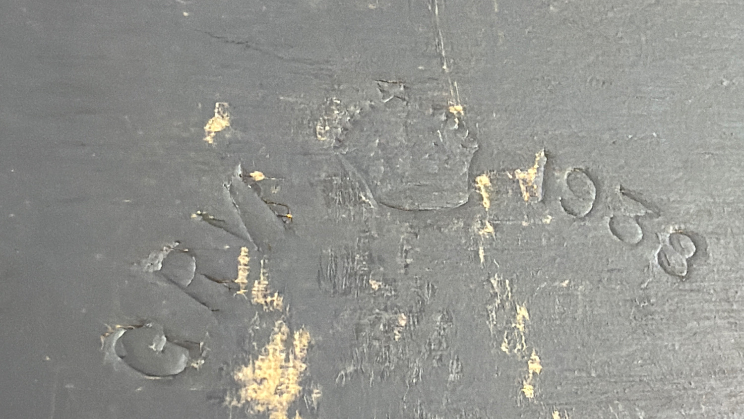 Close-up of worn stamped maker’s markings on the grey-painted casing of the WW2 British gas mask filter sealing machine