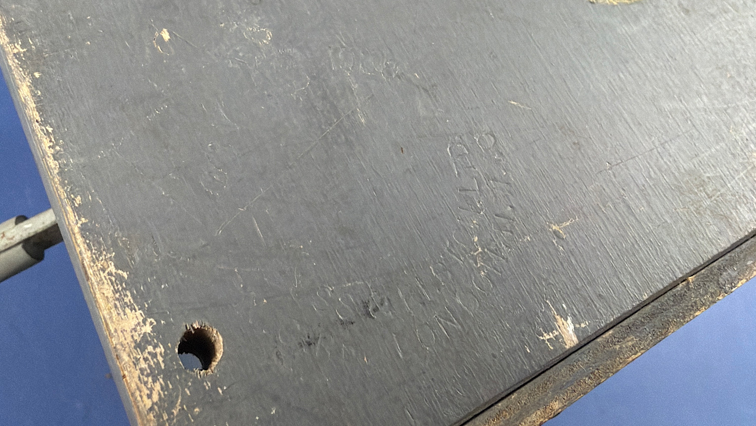 Close-up of the worn grey-painted underside and mounting hole of the WW2 British gas mask filter sealing machine