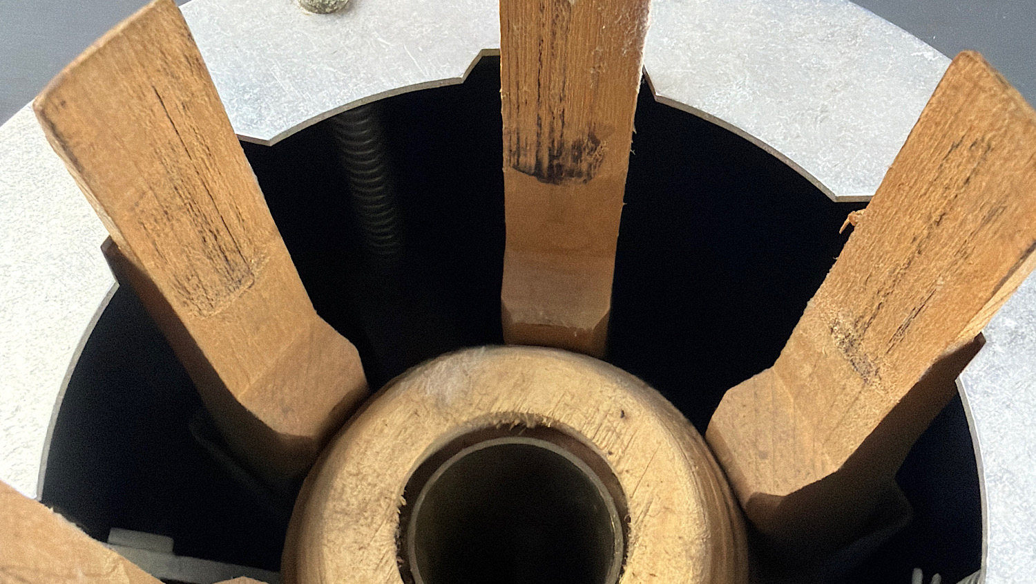 Detailed close-up of the wooden clamping jaws, central former and internal spring mechanism of the WW2 British gas mask filter sealing machine