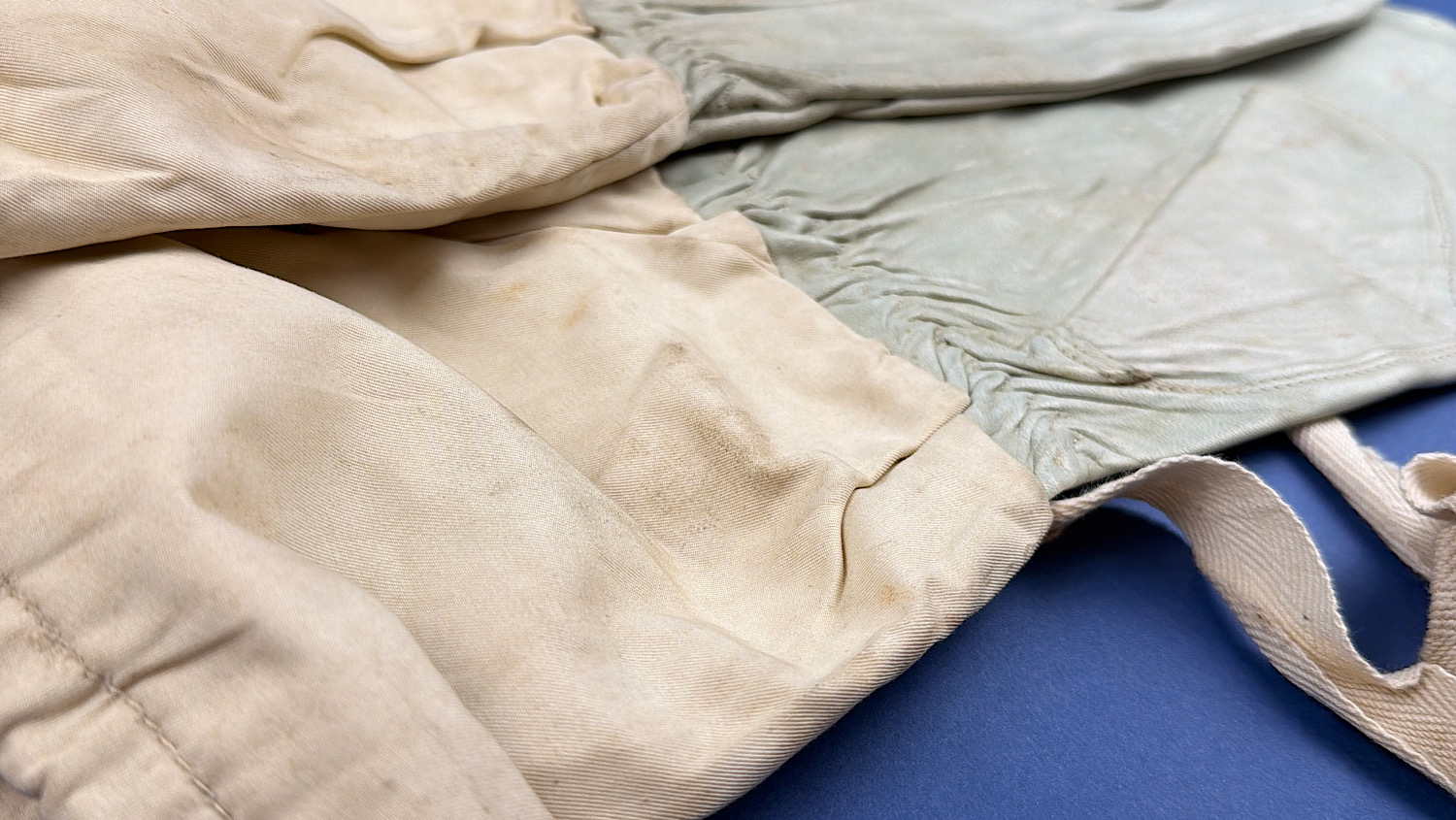 Close-up of fabric cuff and leather hand section on a WW2 British Army mitten showing age-related staining and wear