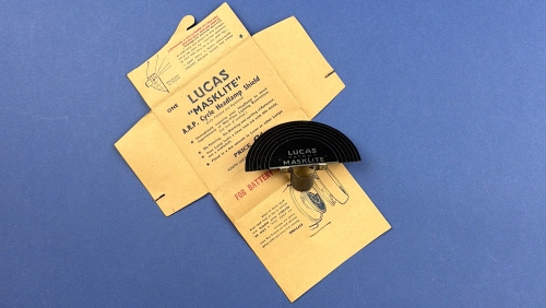 Original WW2 British Home Front Lucas Masklite ARP cycle headlamp shield displayed with its opened original wartime paper packaging.