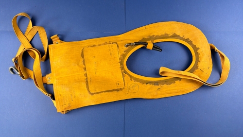WW2 USAAF Type B-4 Mae West life preserver laid flat, showing yellow rubberised body, straps, hoses, fittings and wartime markings.